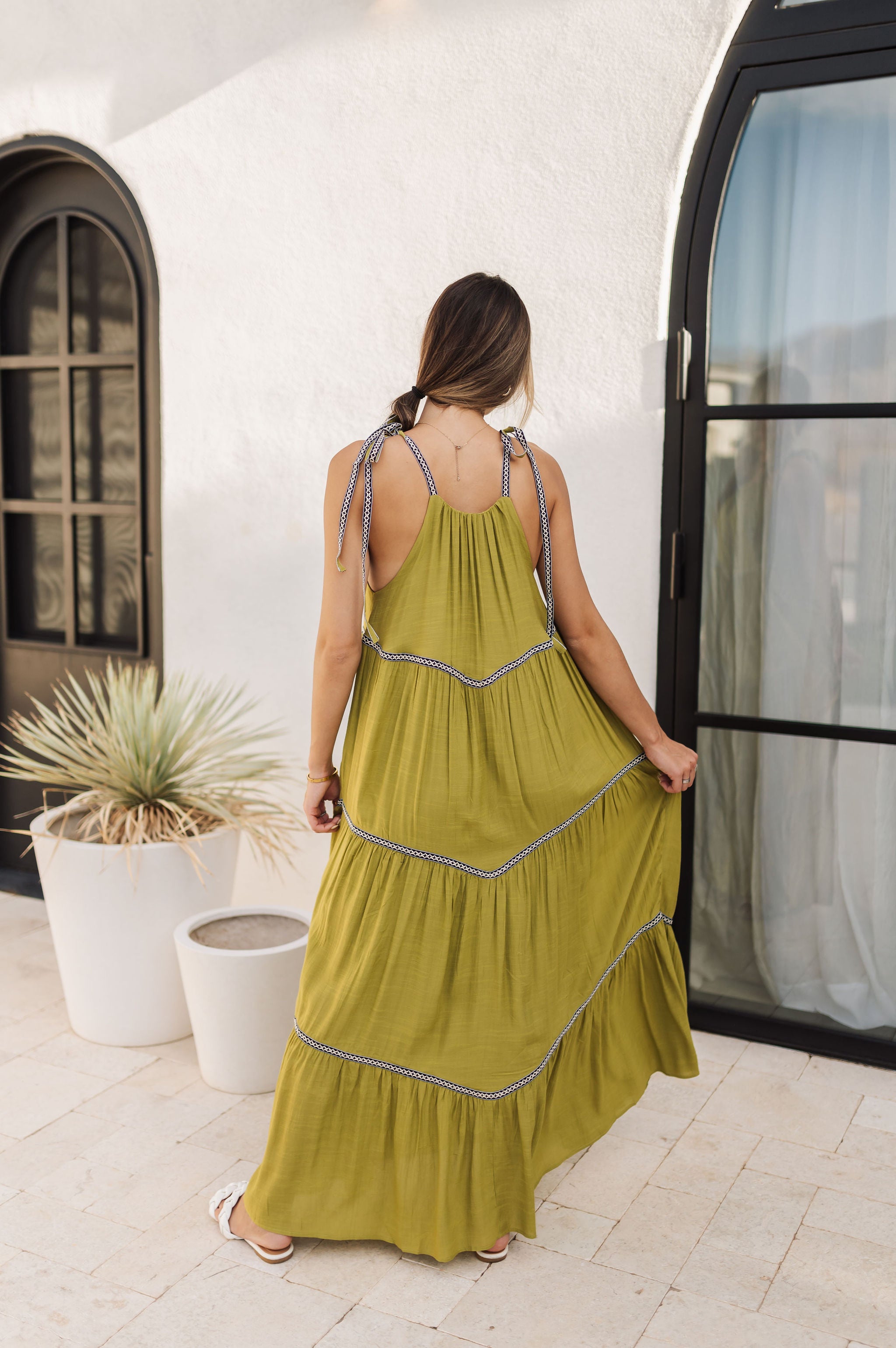 Rear view of Palm Skies Tiered Maxi Dress in green with tiered and blocking details and self tie shoulder straps. 