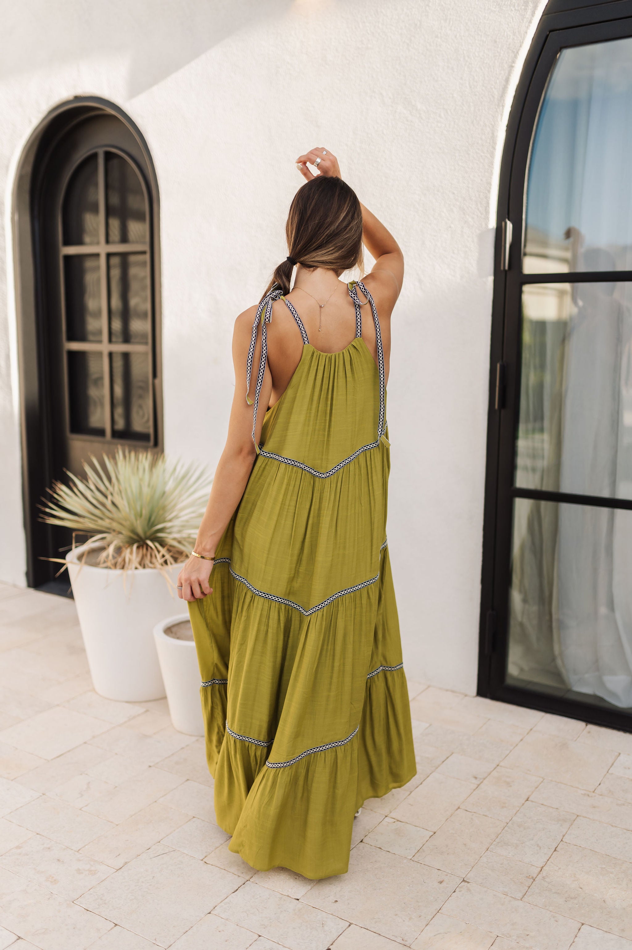 Rear view of Palm Skies Tiered Maxi Dress in green with tiered and blocking details and self tie shoulder straps. 