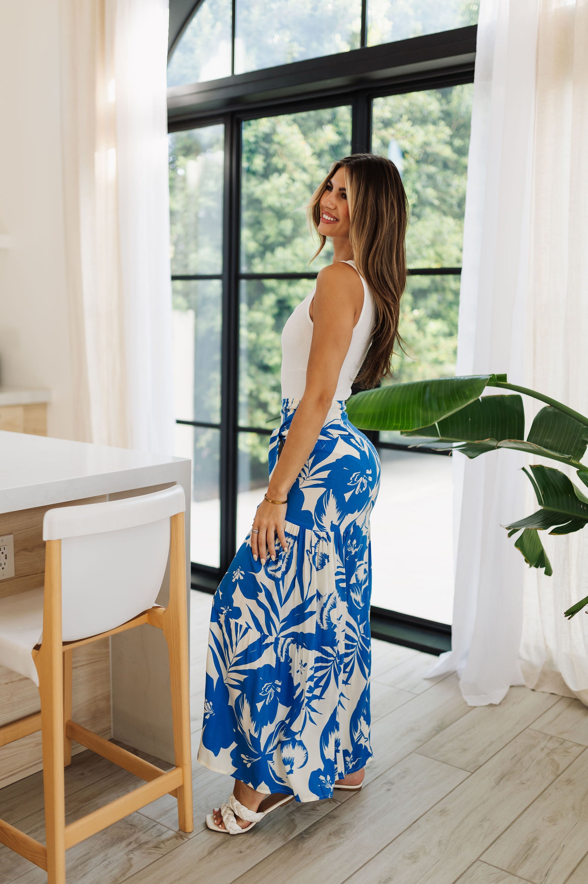 Side view of Coastal Breeze Pants in blue and white tropical print with wide legs.