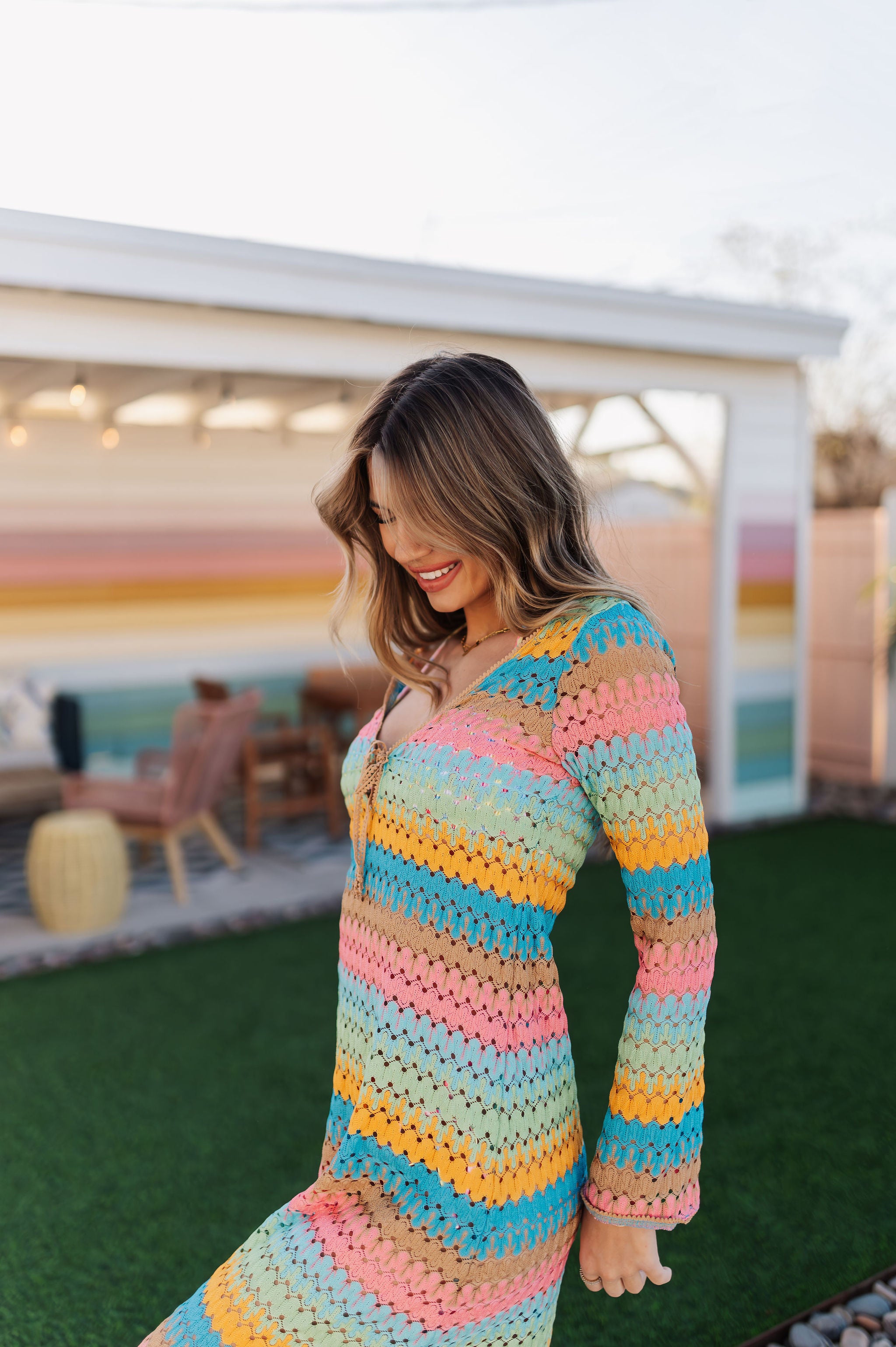 Side angled view of multi-striped crochet Vacay Coverup with long sleeves and tie front.