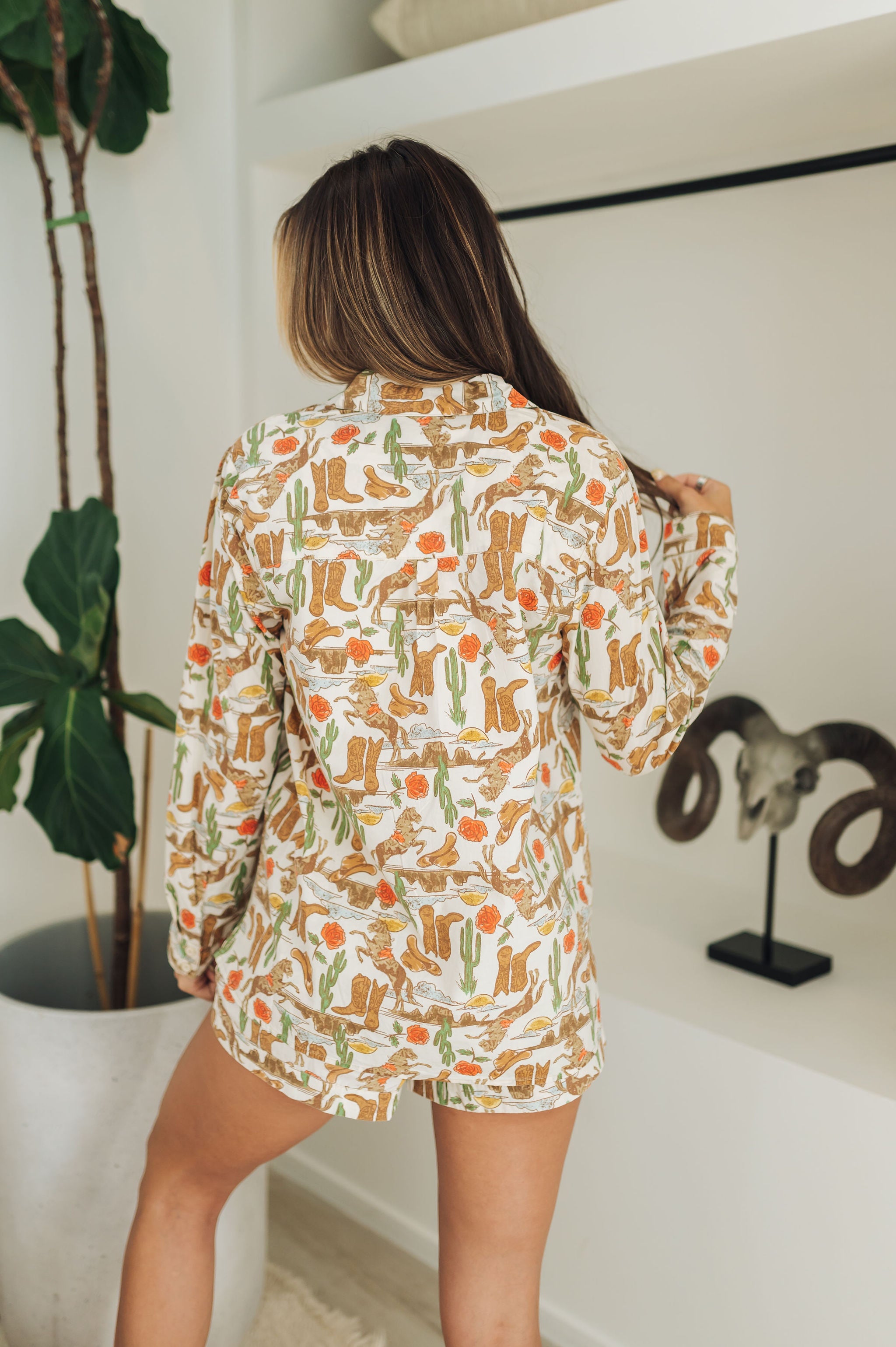 Rear view of Early Riser PJ Set in allover western graphic with long sleeves and short bottoms. 